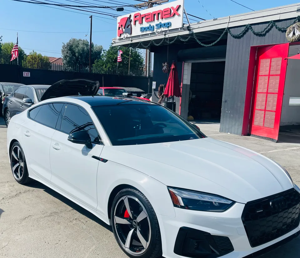 White Audi sedan outside Aramex Body Shop