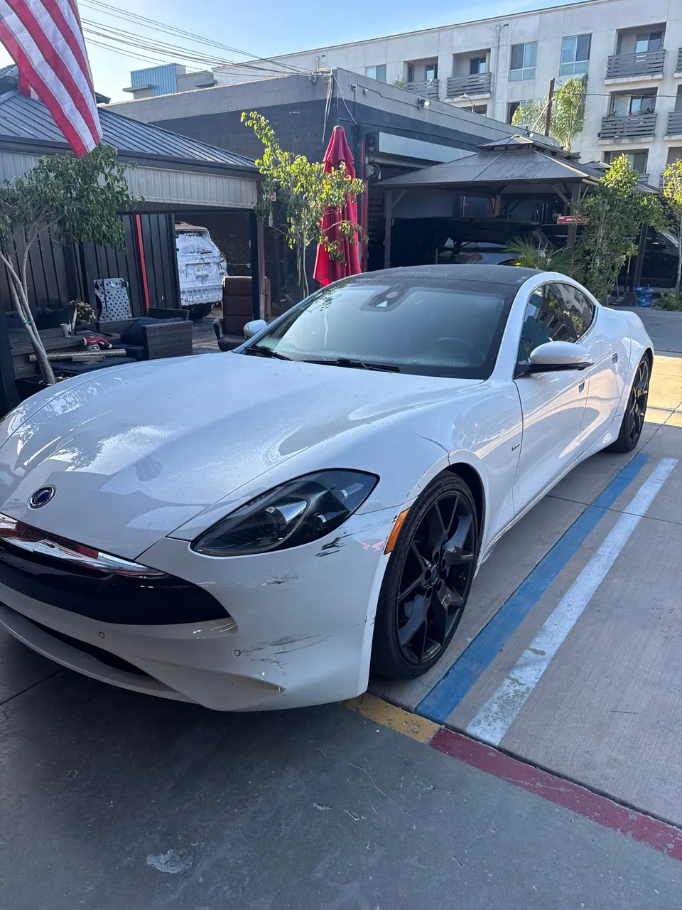 White sports car with front bumper damage at Aramex Body Shop