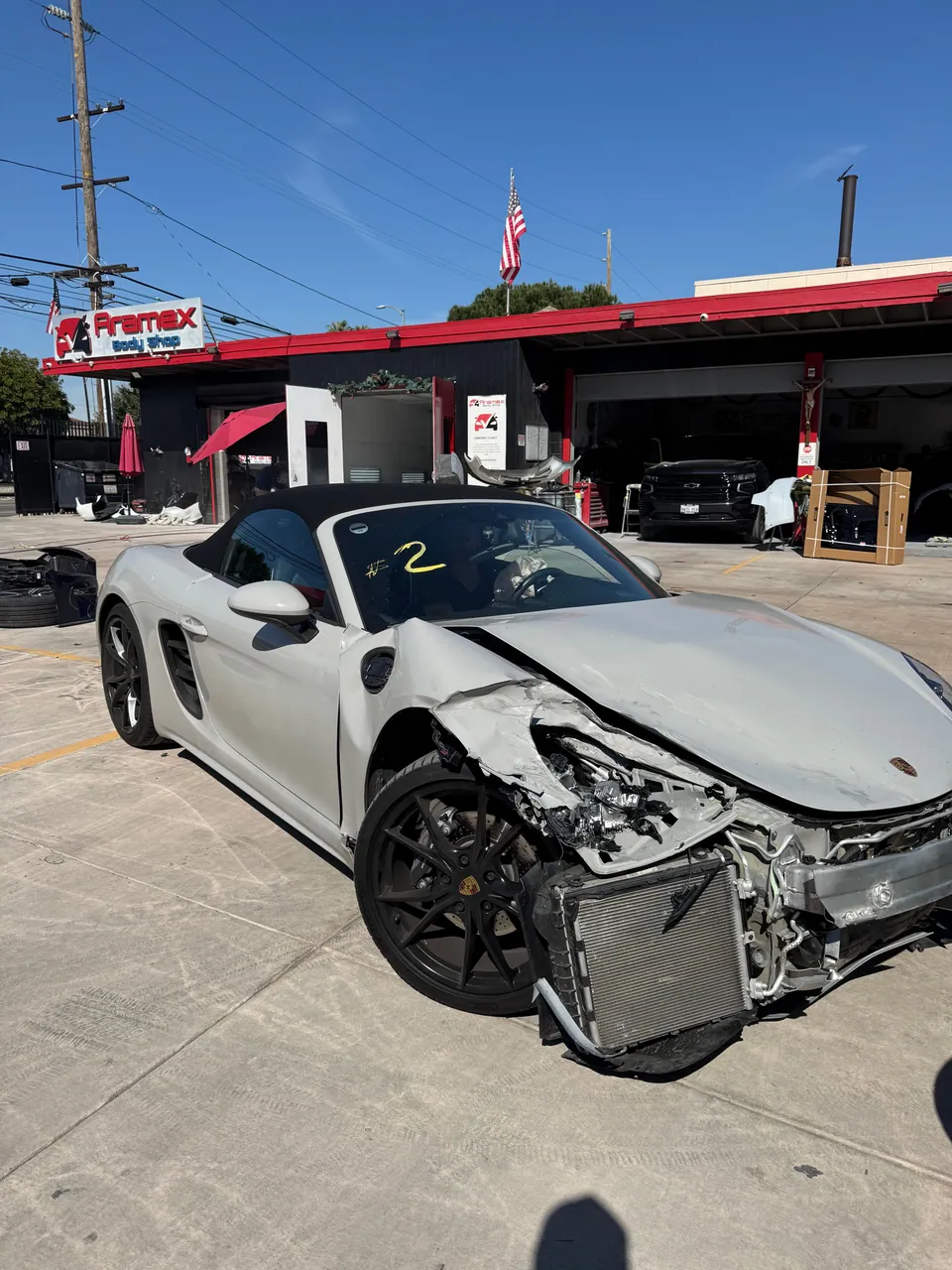 White Porsche convertible with heavy front-end damage
