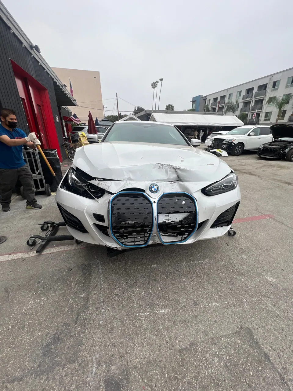 White BMW with front bumper damage in the Aramex lot