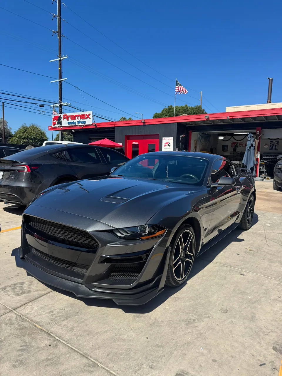 Gray Ford Mustang in front of the Aramex garage