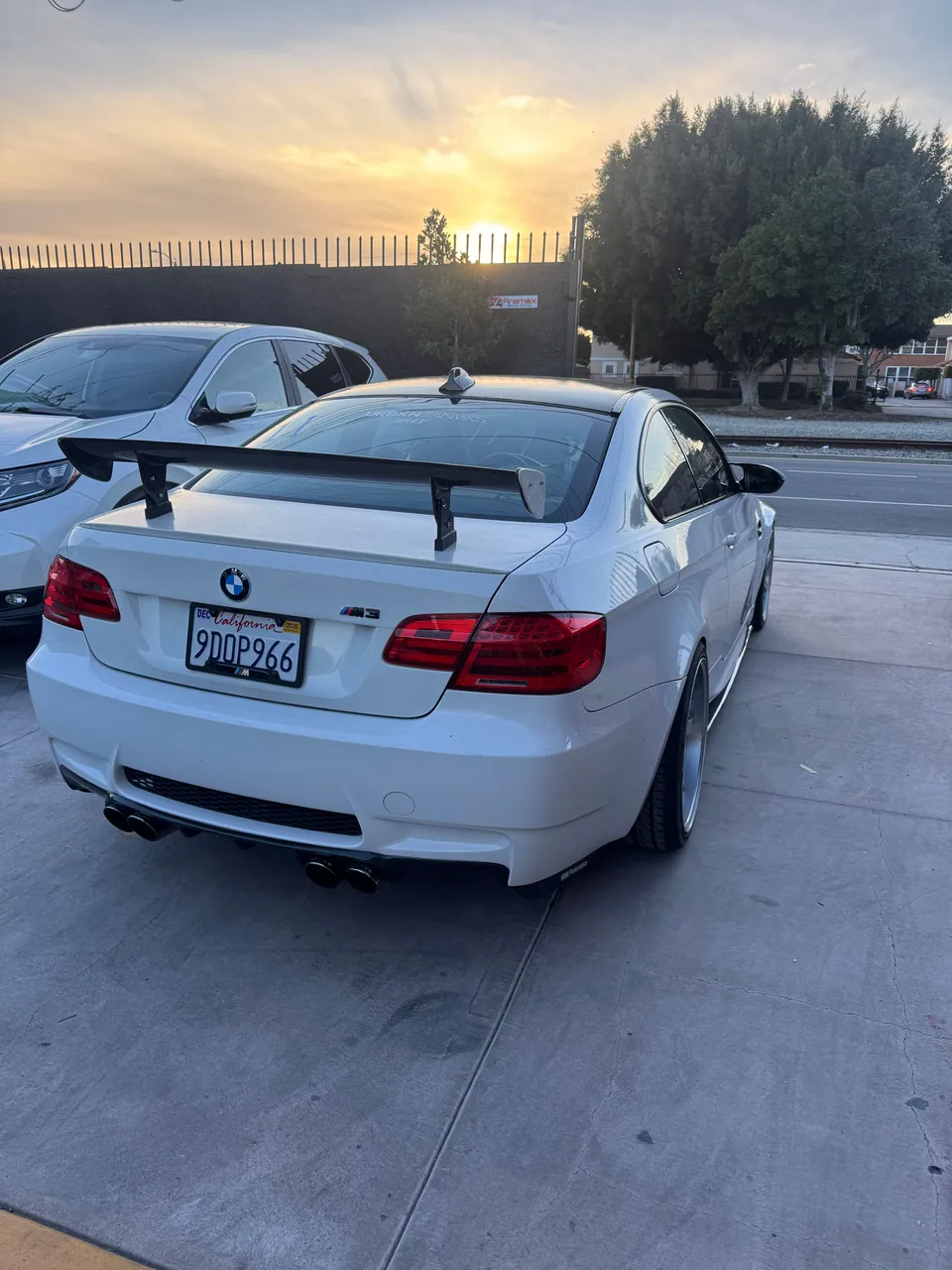 White BMW coupe in the Aramex lot at sunset
