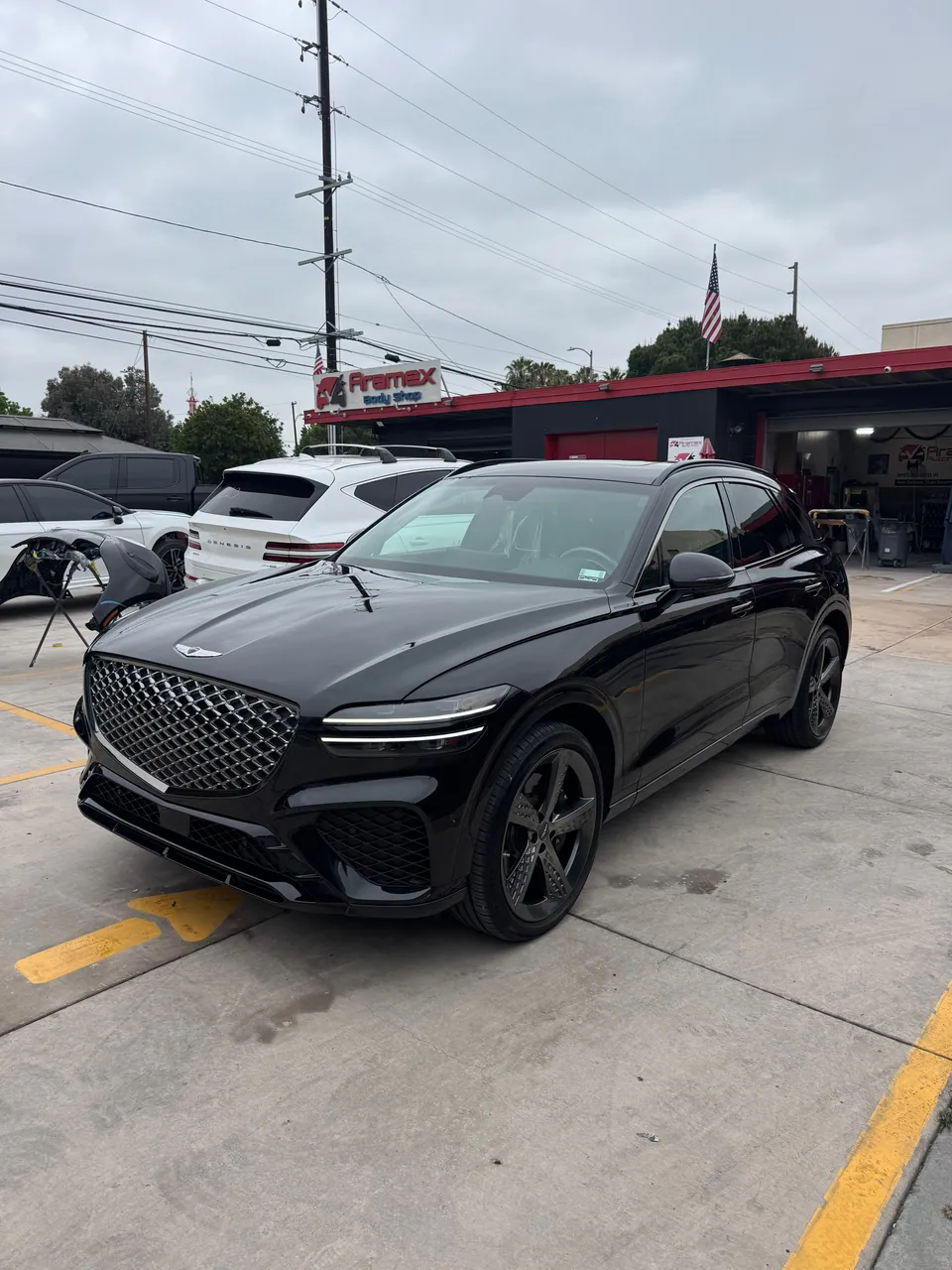 Black Genesis SUV in front of Aramex Body Shop