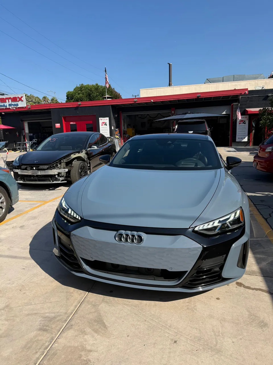 Light gray Audi facing the camera outside the shop
